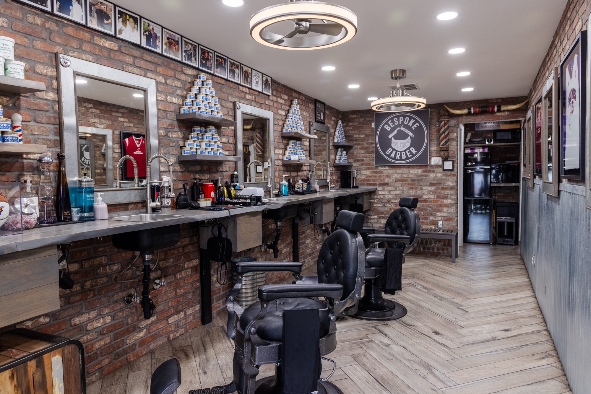 Professional interior shot of Bespoke Barber with exposed brick, mirrors, and classic chairs